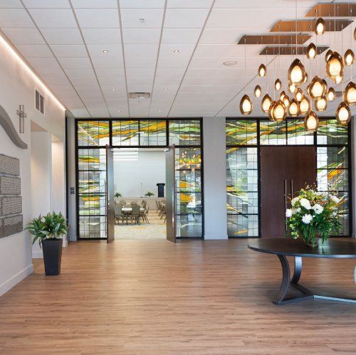 There is a table with flowers on it in the middle of the room.