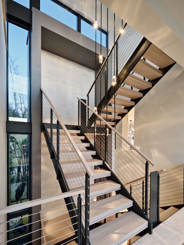 A modern staircase with wooden steps and a metal railing