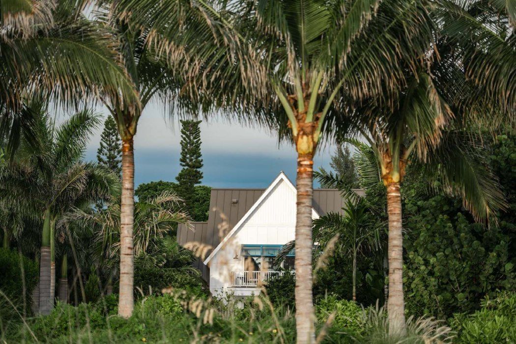 a large white house sits in the middle of a lush green  lawn