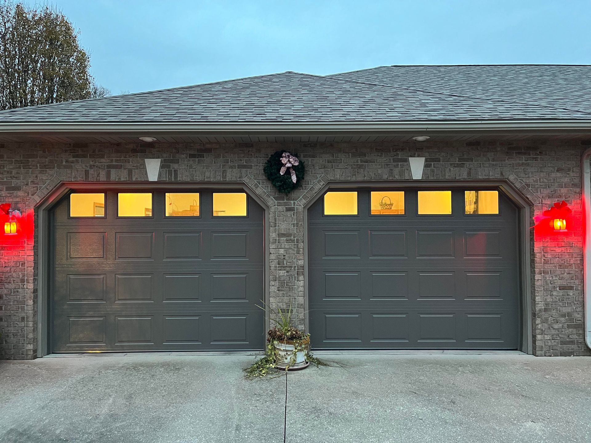 There are two garage doors on the side of a house.
