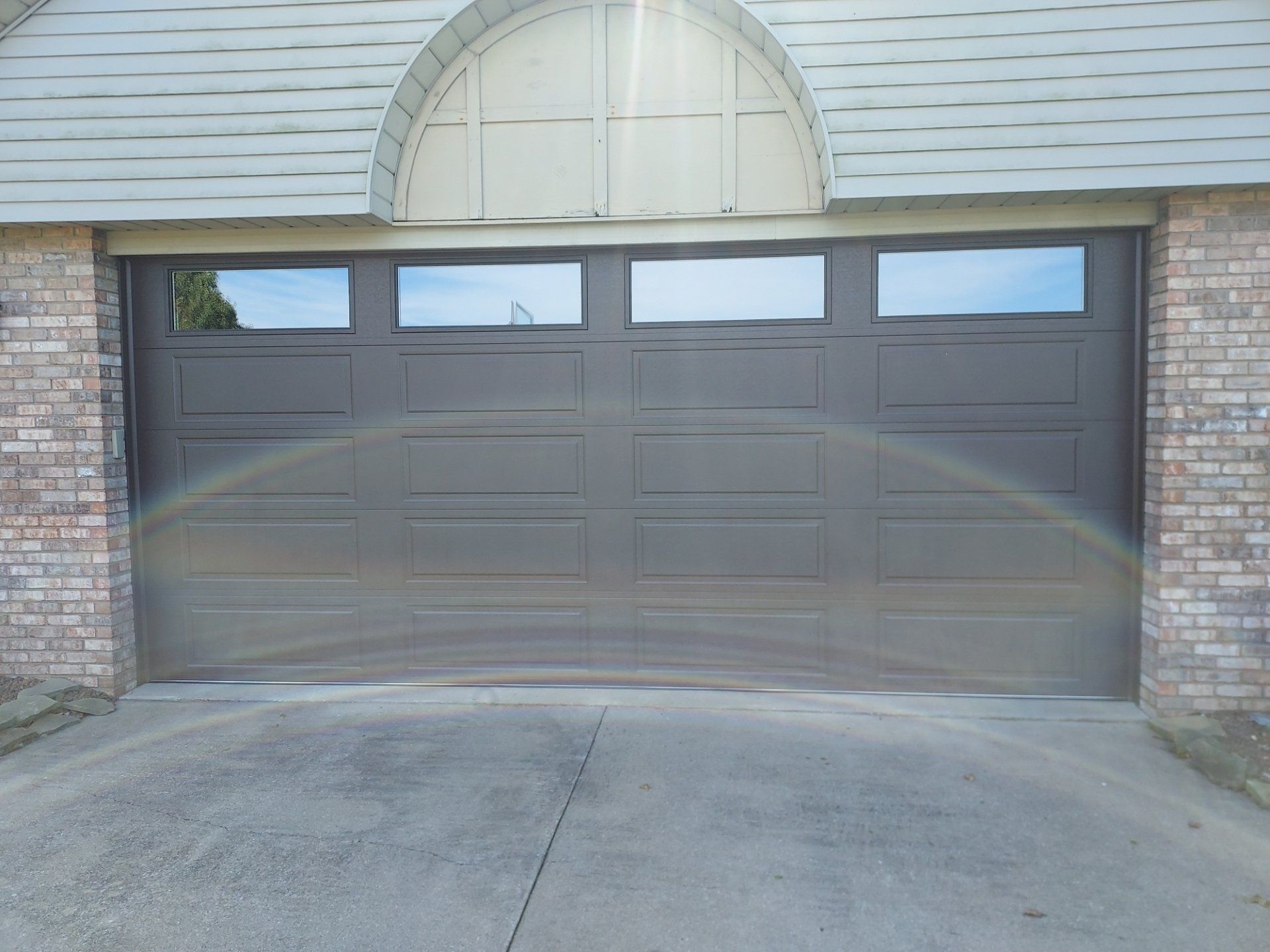 A garage door with a rainbow in the window