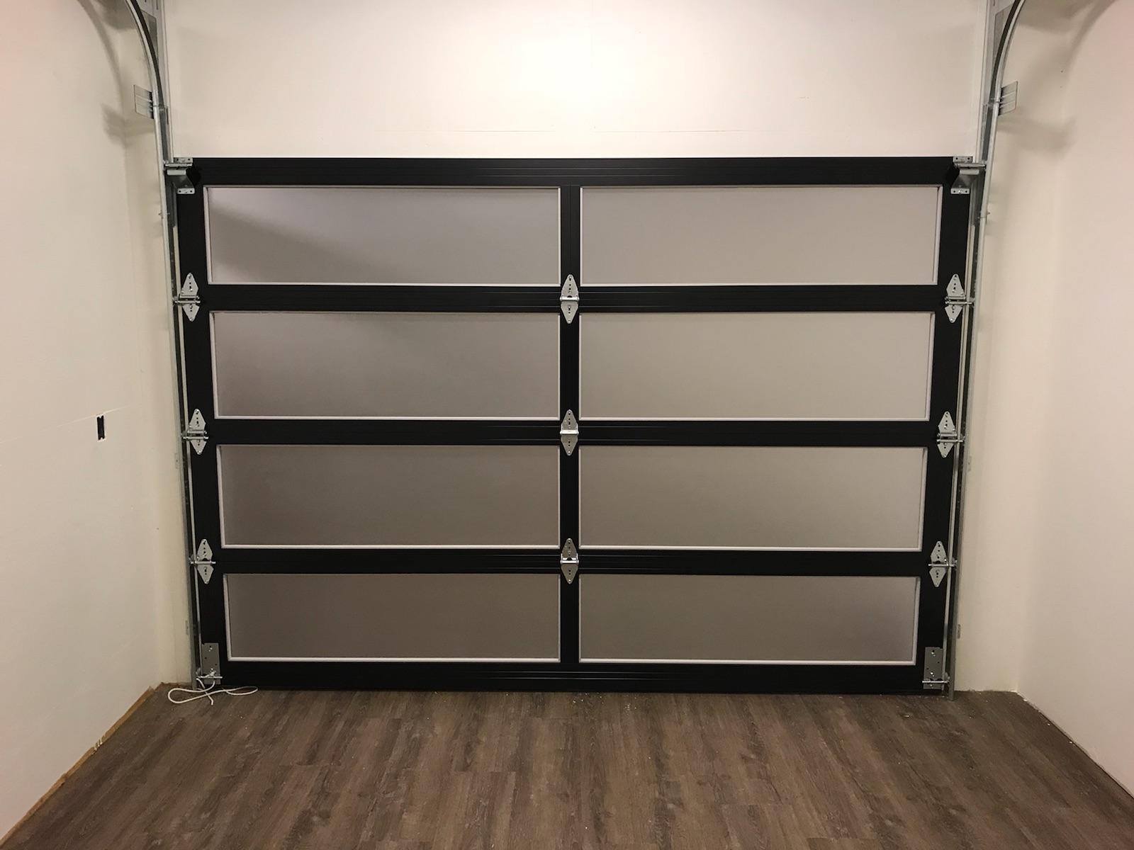 A garage door with a black frame and frosted glass.