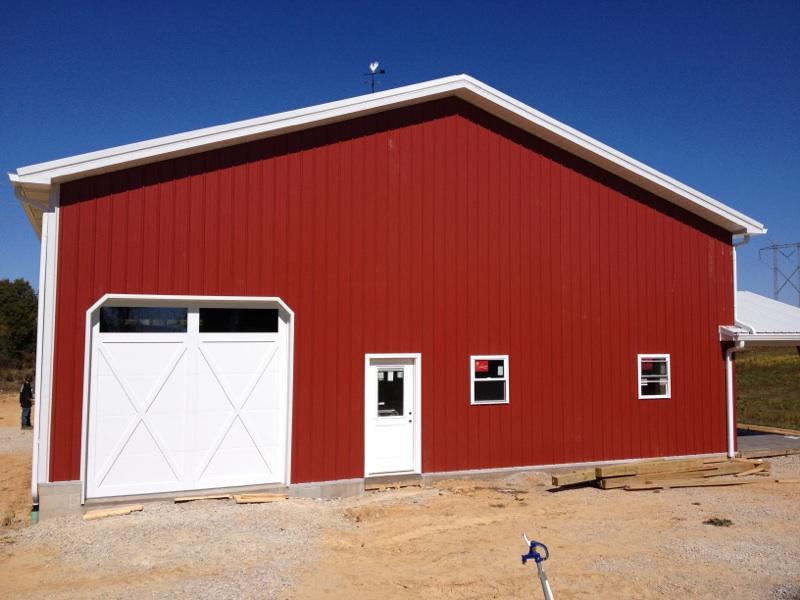 A red barn with a white door and windows