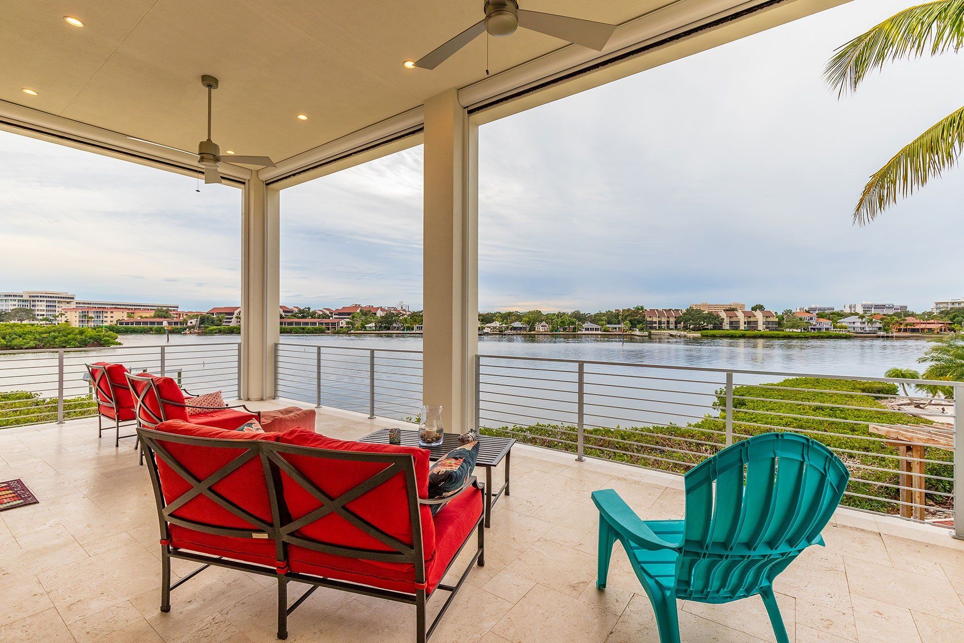 A patio with a view of a lake and a couch and chairs.