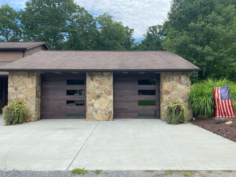 A house with a large garage door and an american flag in front of it.