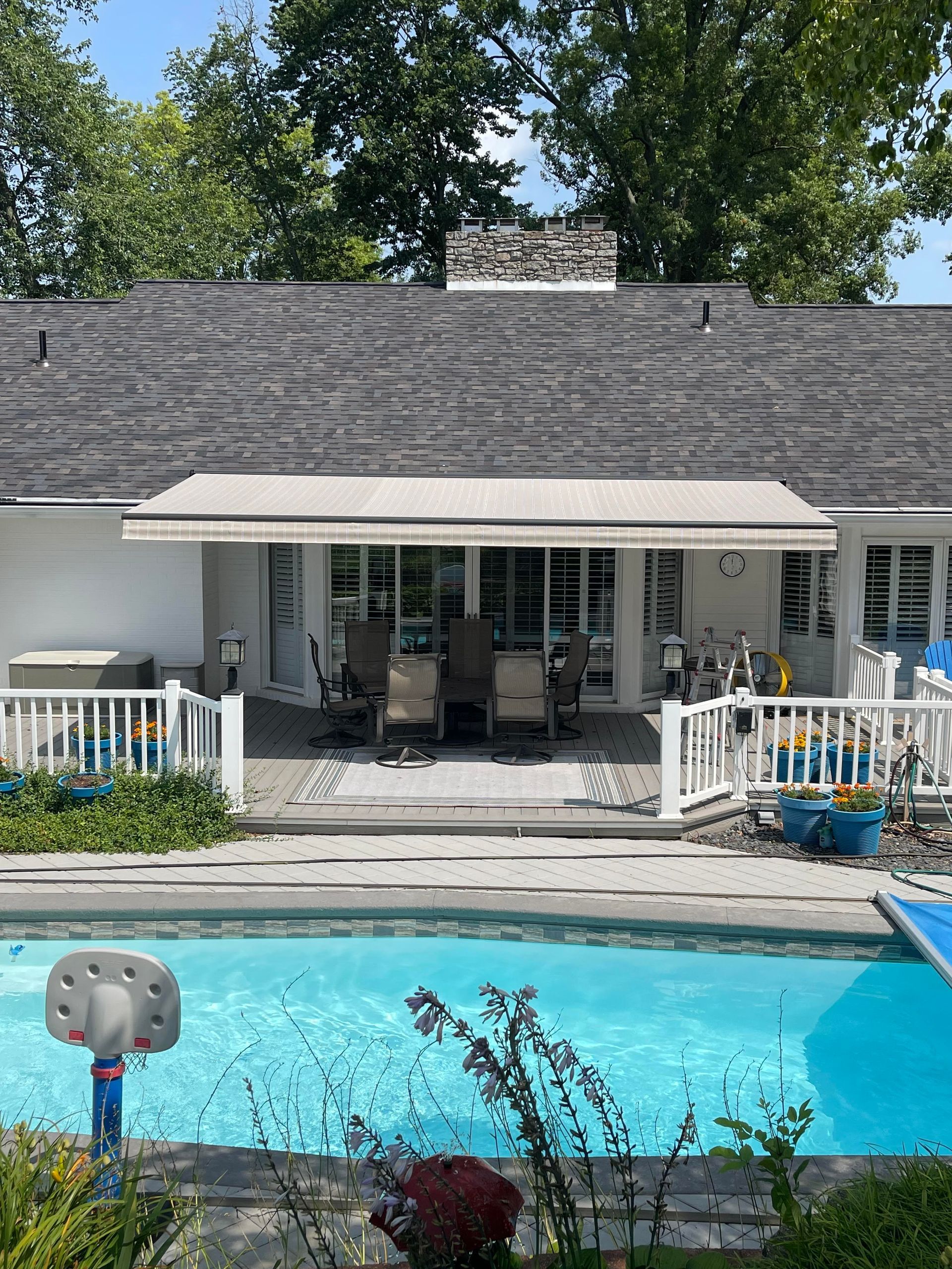 A house with a large swimming pool in front of it.