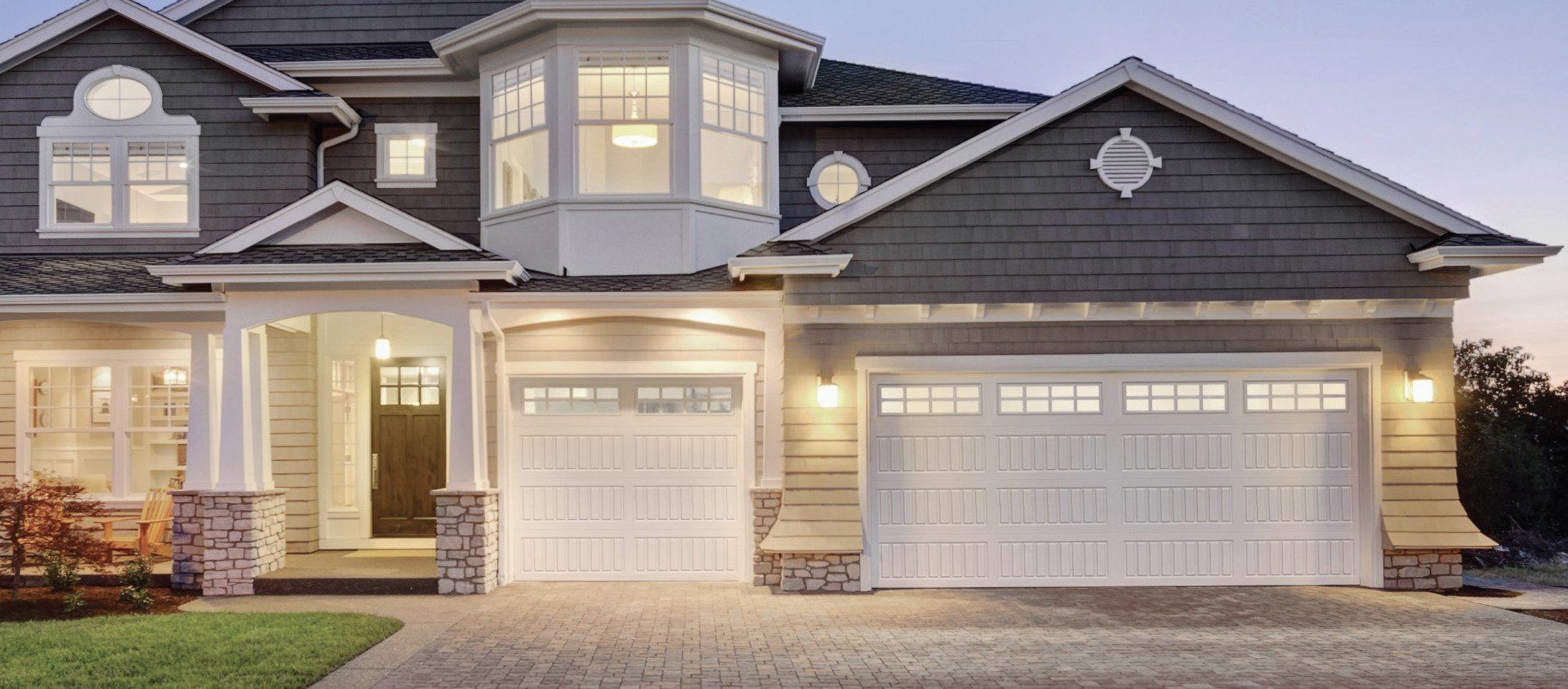 A large house with two garage doors and a large driveway.