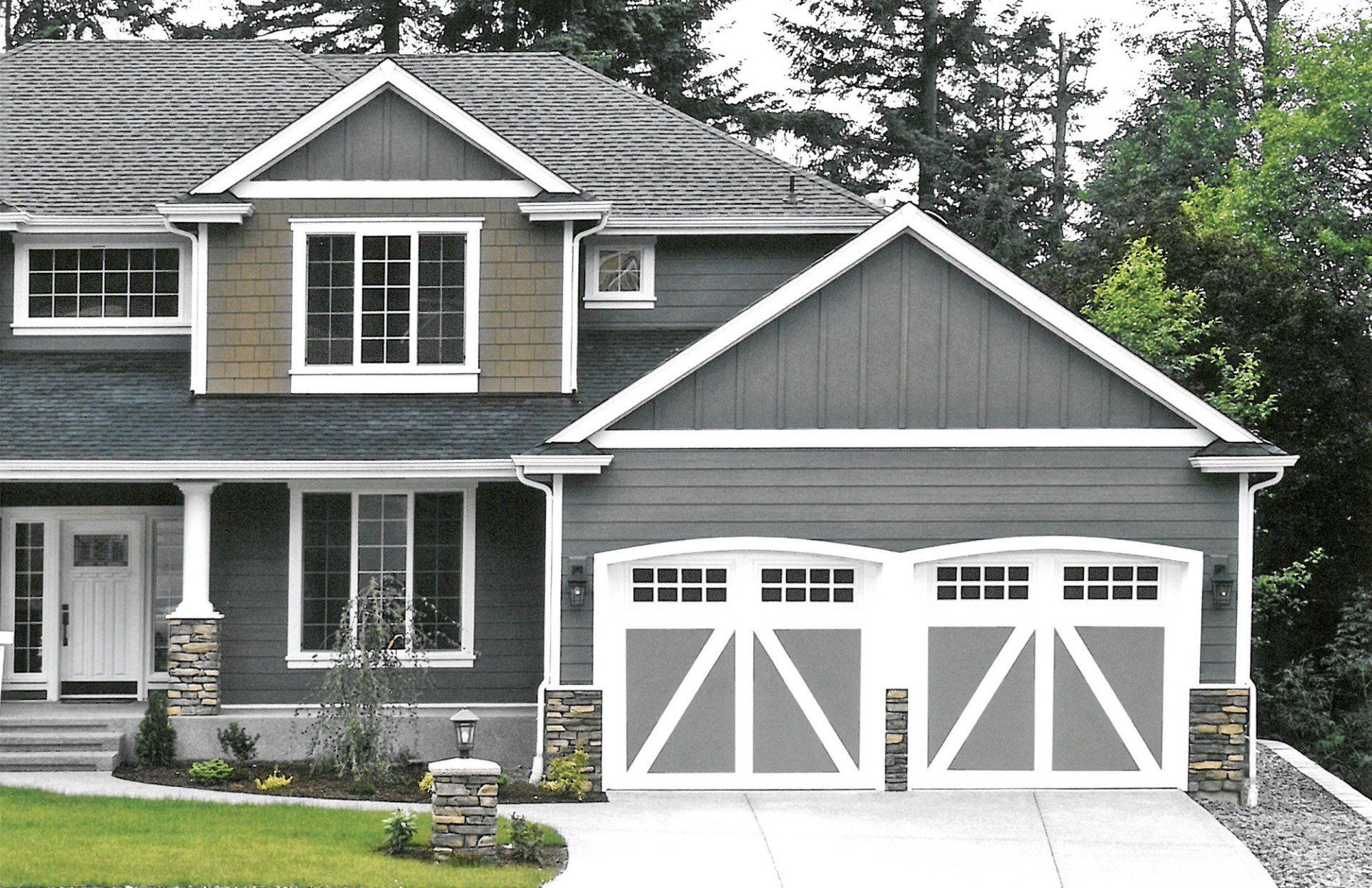 A large house with two garage doors and a driveway