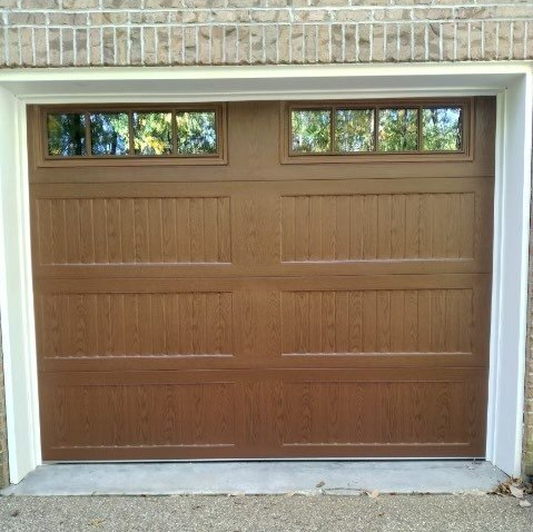 A brown garage door with a window on the side of it.