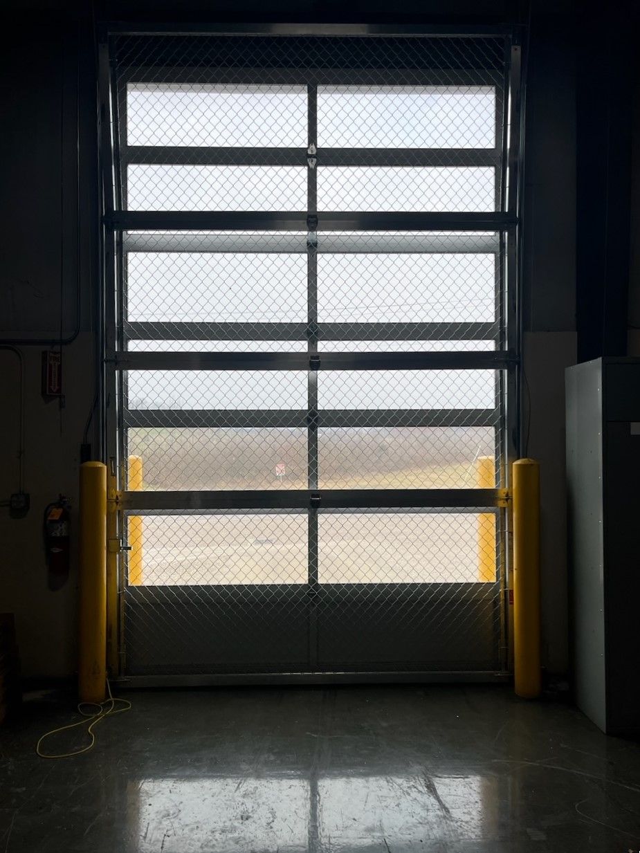 A garage door with a chain link fence and a large window.