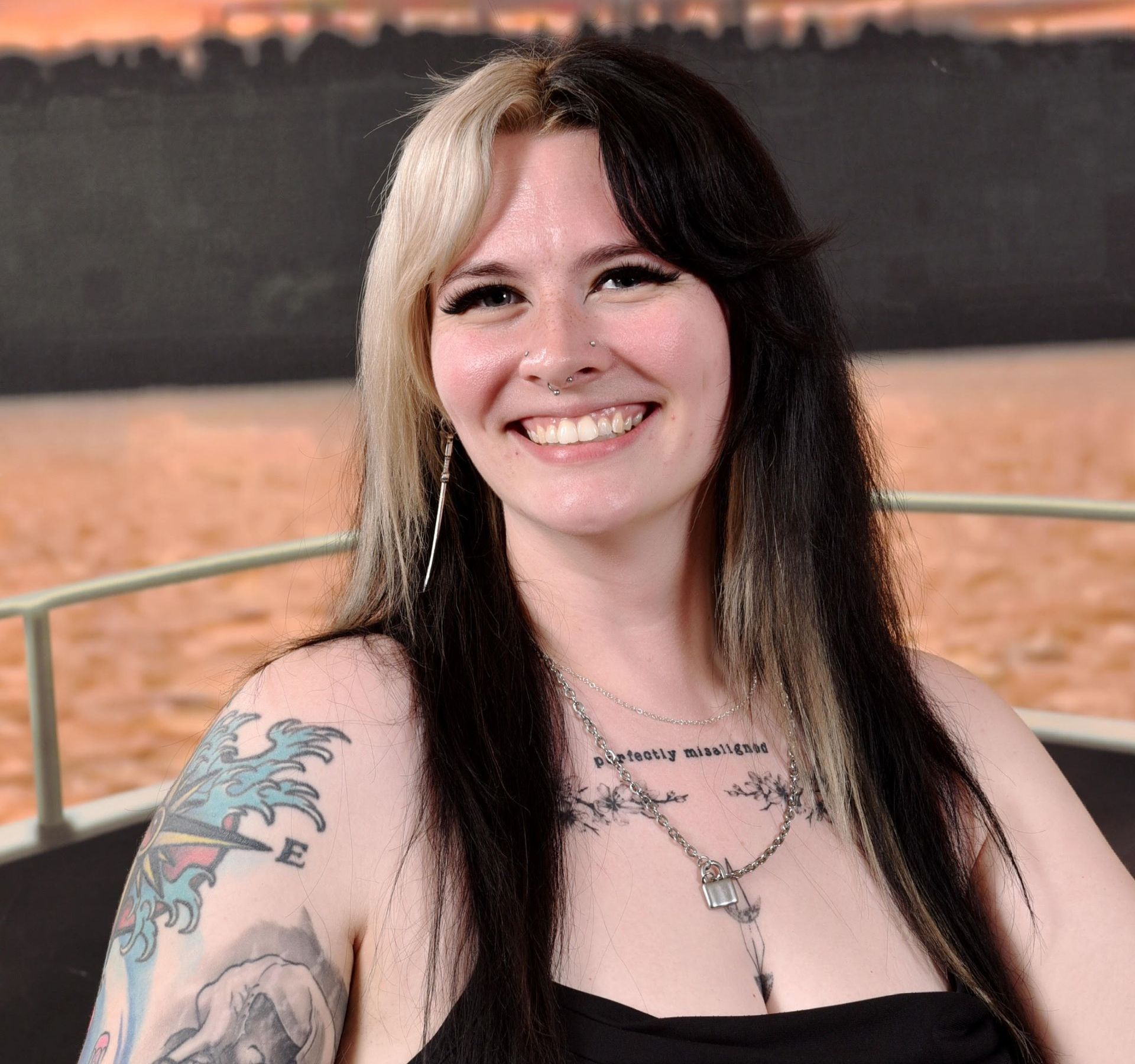 A woman with a tattoo on her arm is smiling
