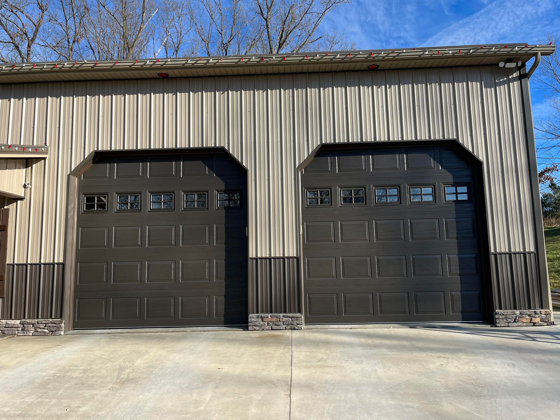 There are two garage doors on the side of a building.
