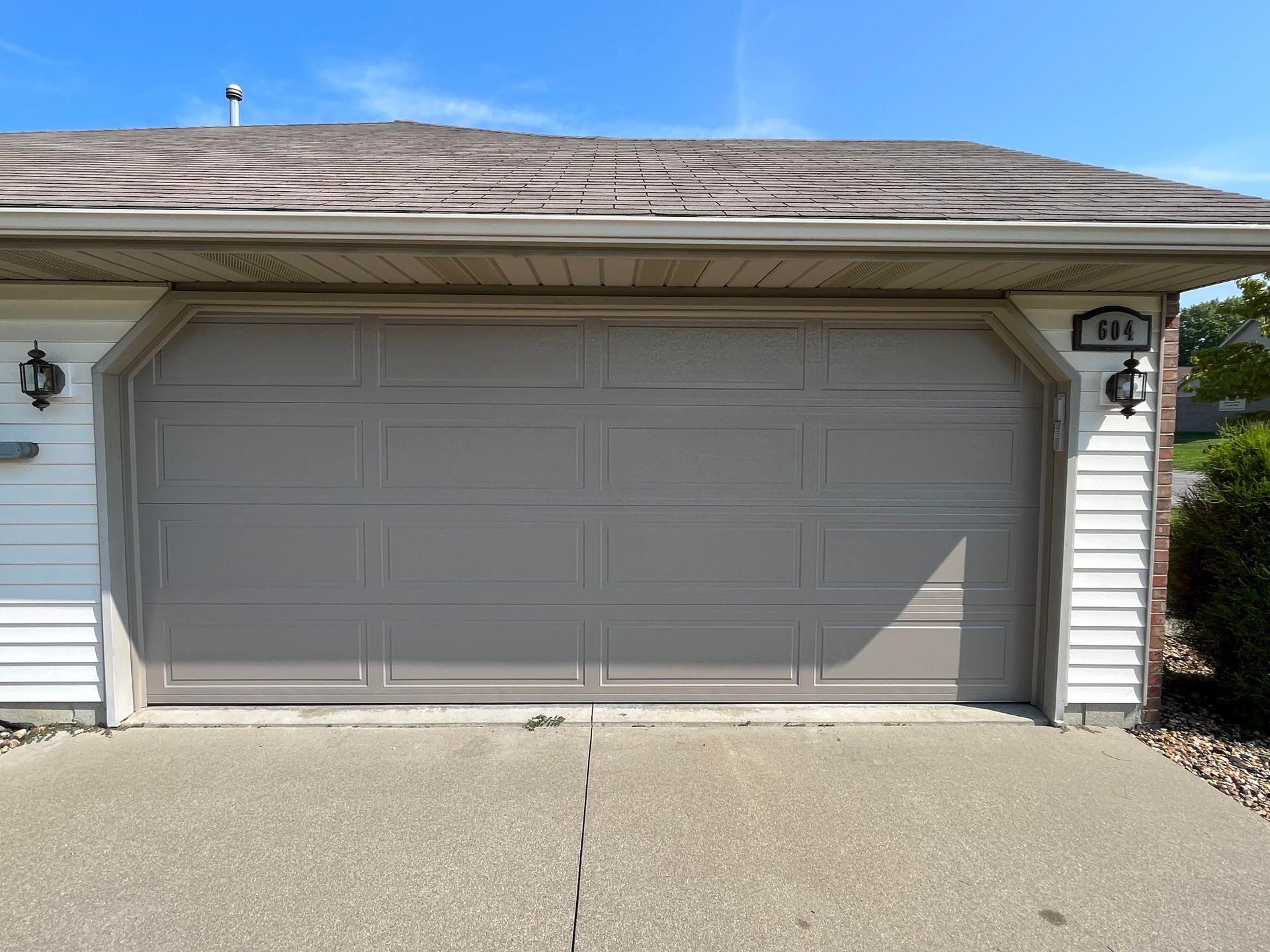 A white house with a gray garage door