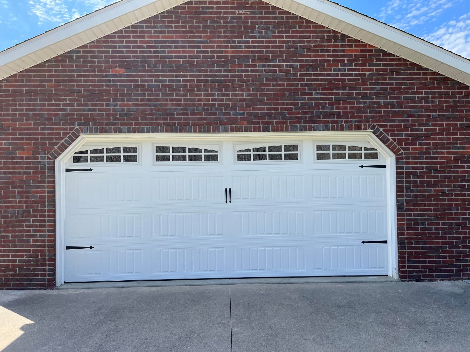 A red brick garage with a white garage door