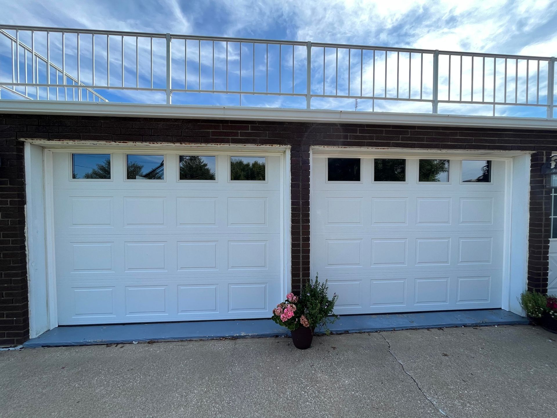 A couple of white garage doors on a brick building