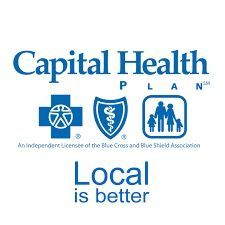 A woman in an apron and yellow gloves is holding a plate and a sponge.