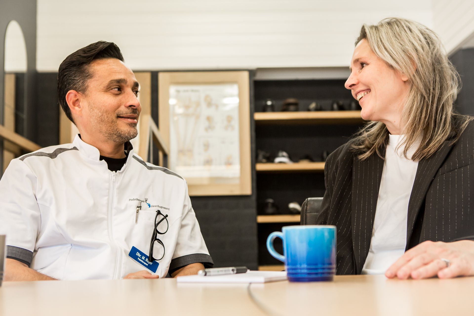 Een man en een vrouw zitten aan een tafel met elkaar te praten.