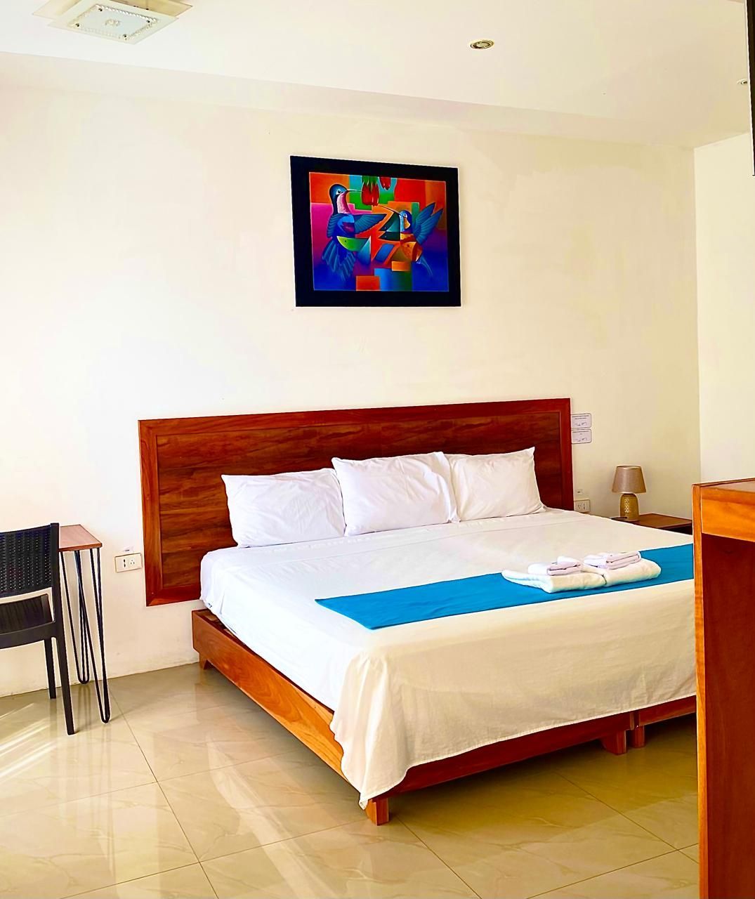 Un dormitorio con una cama grande y un cuadro en la pared encima.