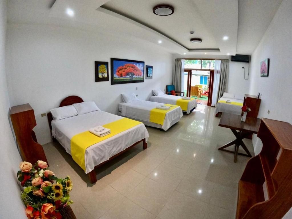 Una habitación de hotel con tres camas y un escritorio.