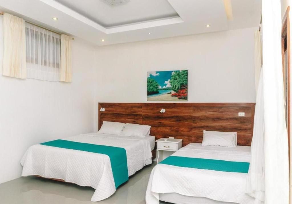 Una habitación de hotel con dos camas y un cuadro en la pared.