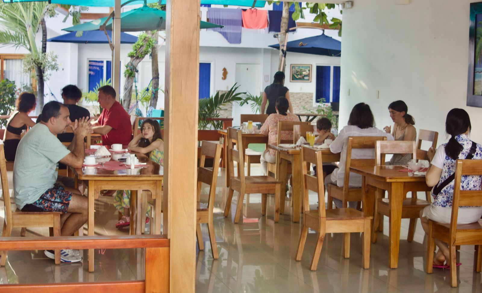 Un grupo de personas están sentadas en mesas en un restaurante.