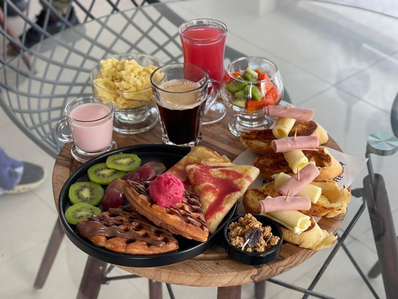 Dos copas de martini están en una mesa frente a una piscina.