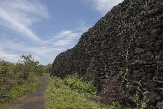 Hay un gran muro de piedra en el medio de un campo.