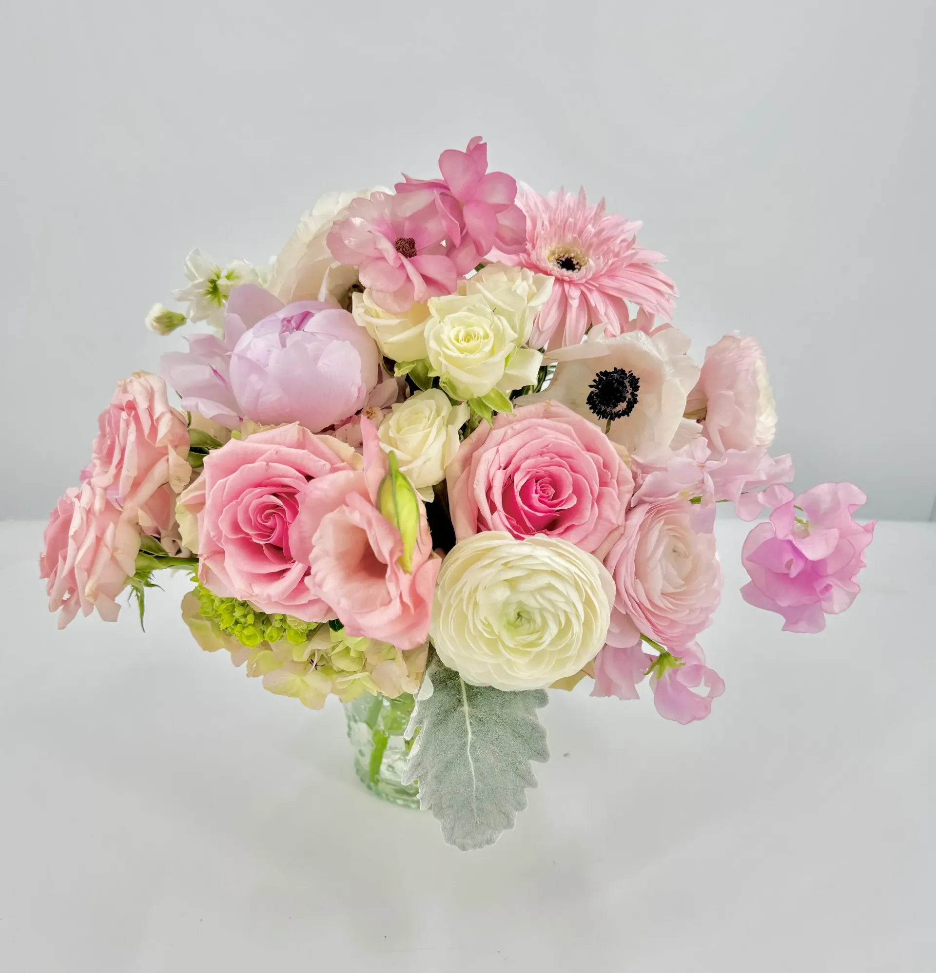 Bouquet of pink and white flowers in a clear vase.