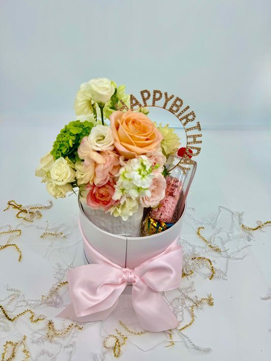 Arrangement of pastel flowers in a white box with a pink bow and 