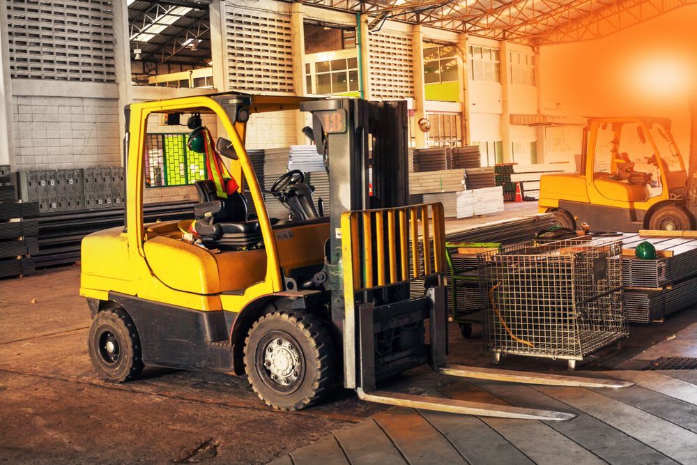 Yellow Forklift in a Warehouse Moving Metal Crates, Another Forklift in Background — Des’s Driving School in Moruya, NSW
