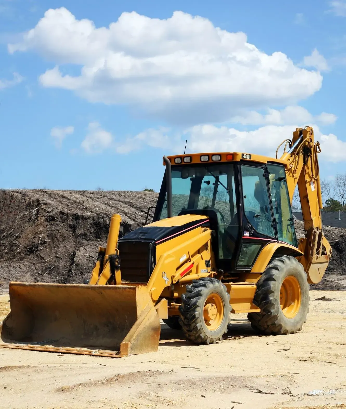 Yellow Backhoe on a Construction Site With a Blue Sky — Des’s Driving School in Callala Bay, NSW