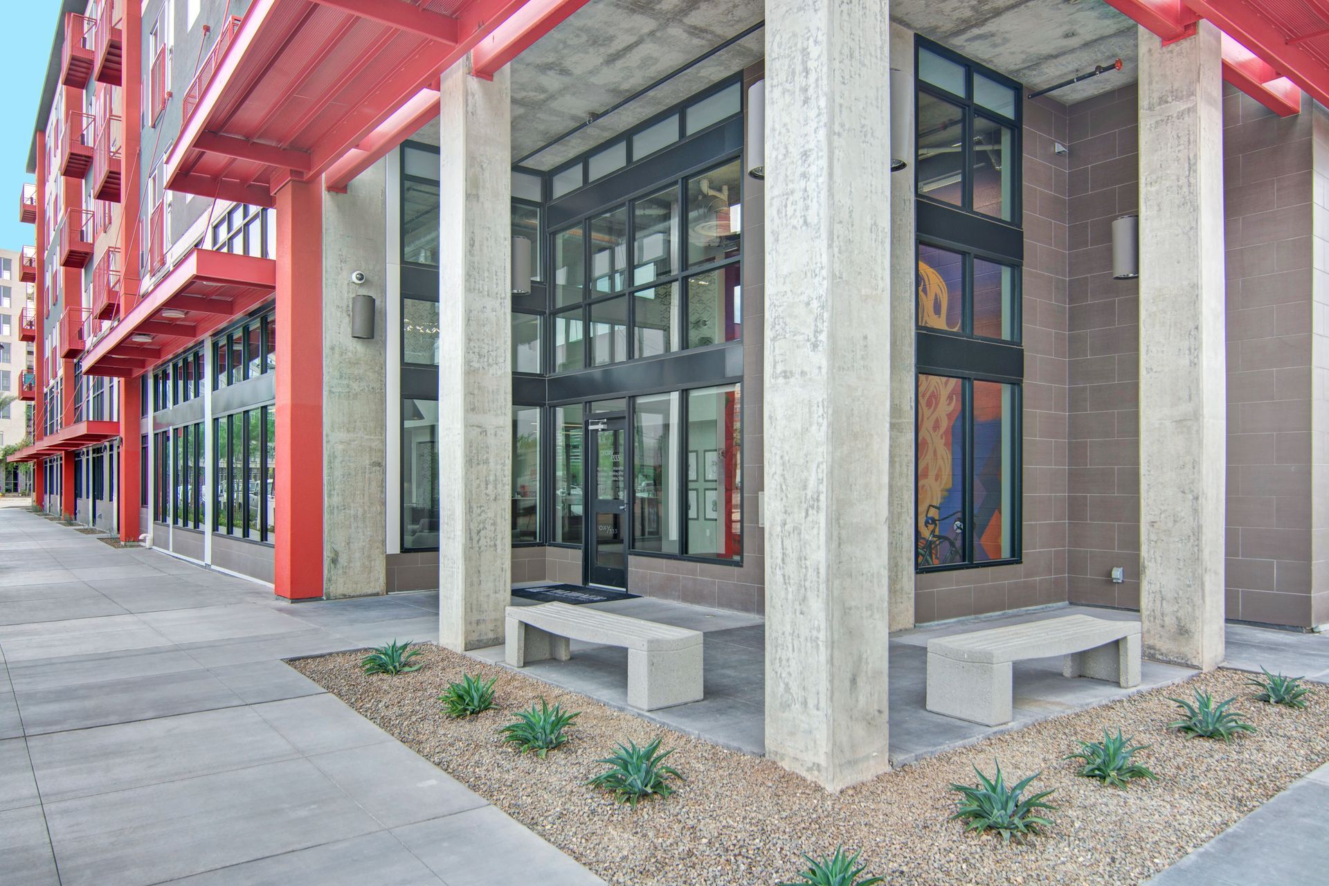 A building with a lot of windows and benches in front of it.