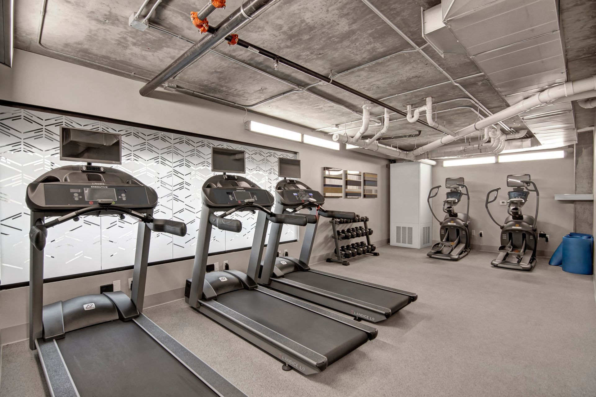 A gym with a lot of treadmills and exercise equipment.