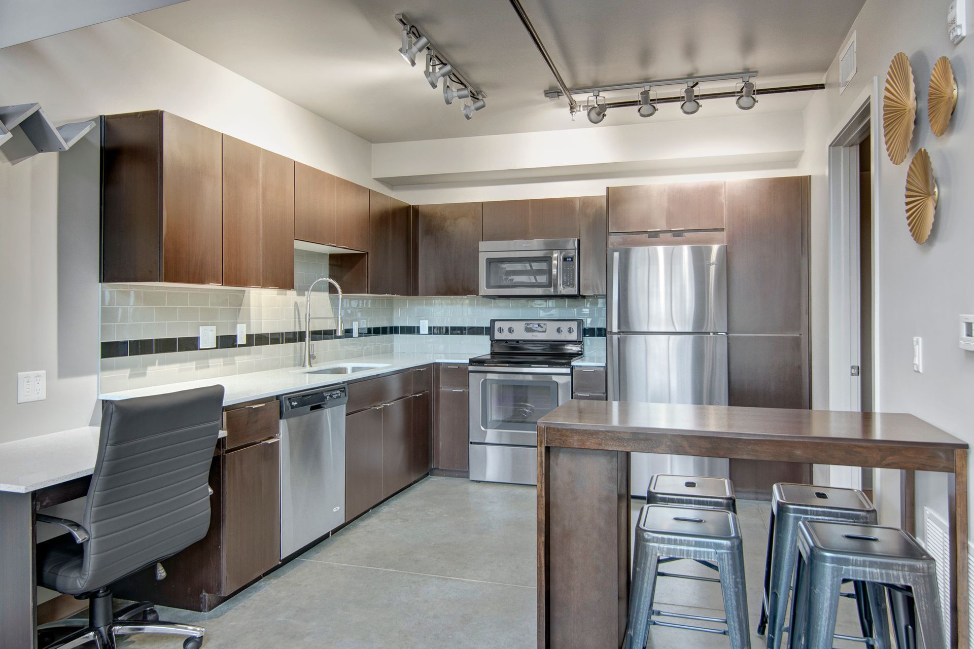 A kitchen with stainless steel appliances and wooden cabinets.