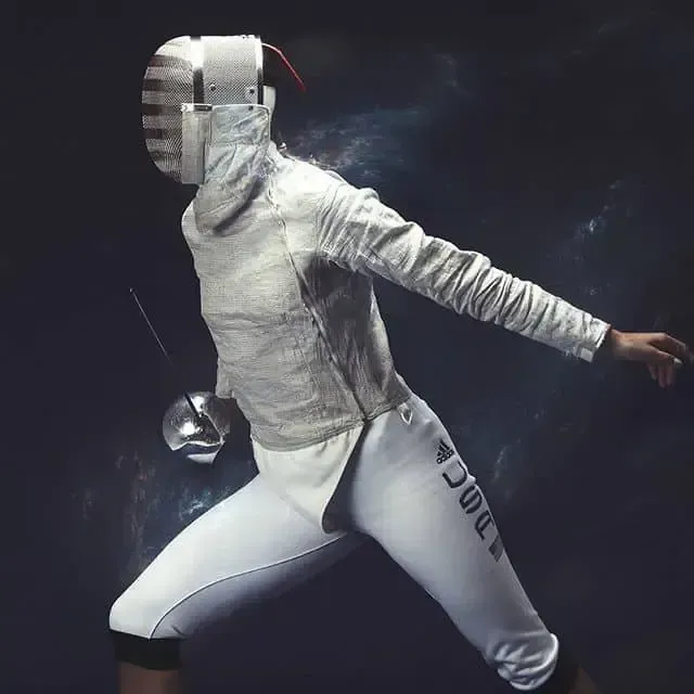 Fencer in white uniform lunging with a foil; headgear and mask on. Dark background.