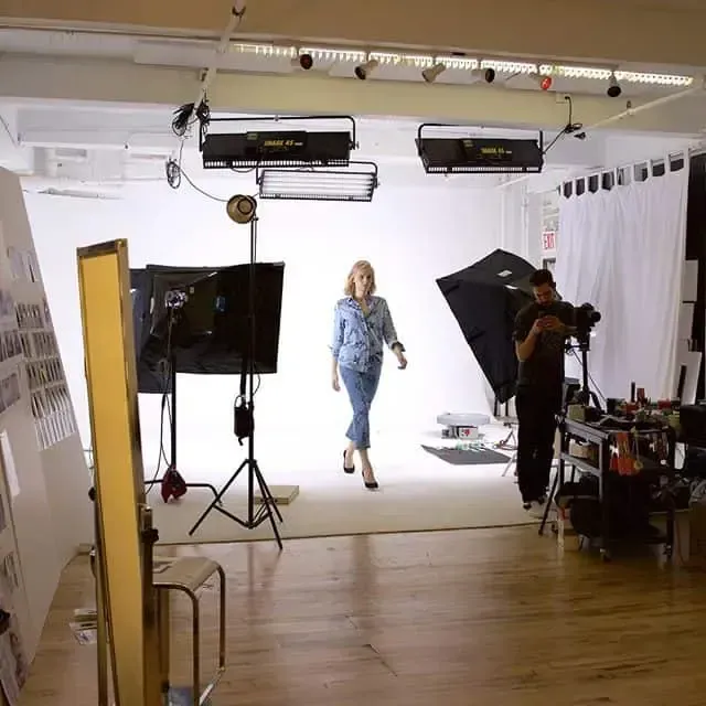 Woman in studio walking towards camera, posing for photoshoot.