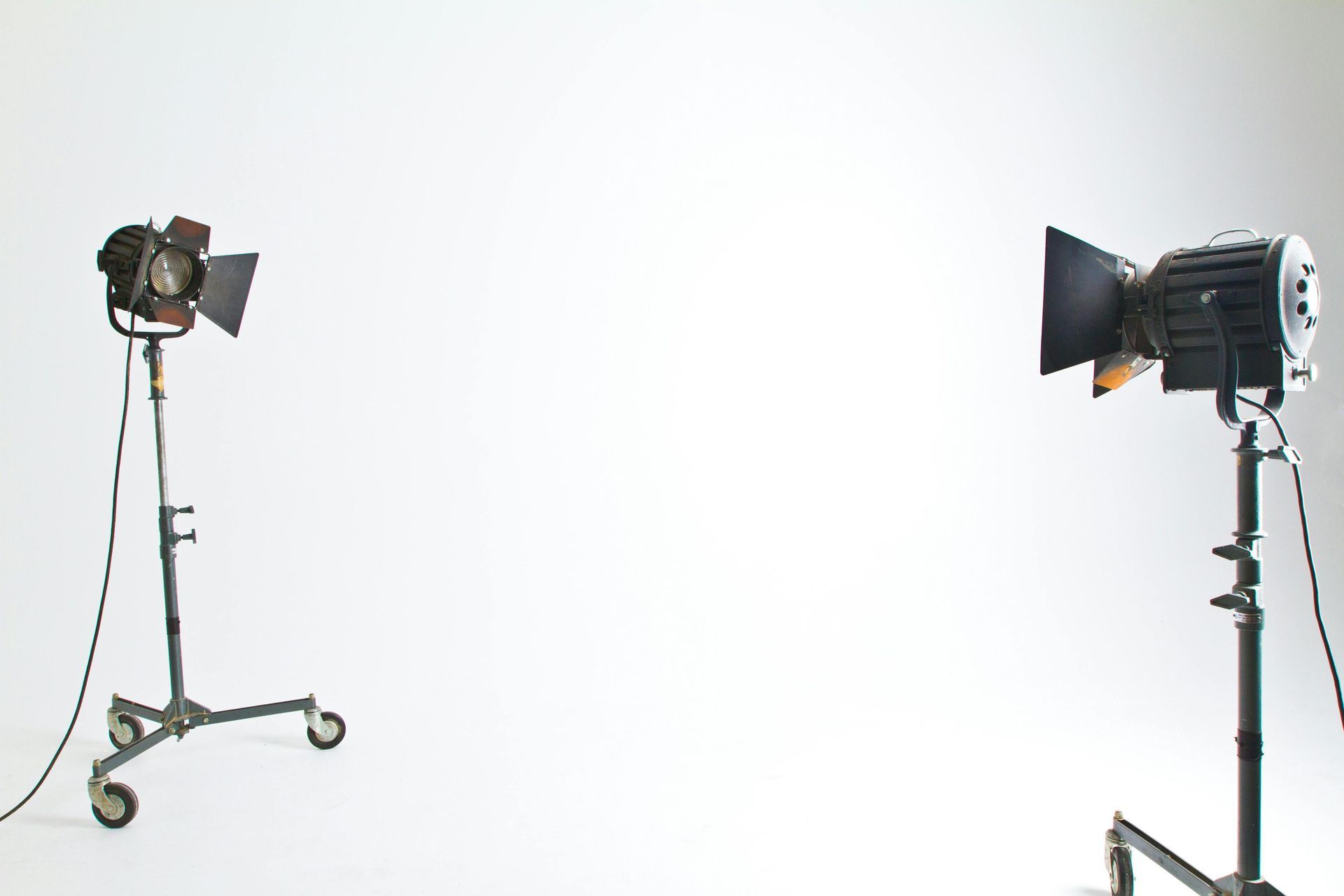 Two studio lights on stands against a plain white backdrop.