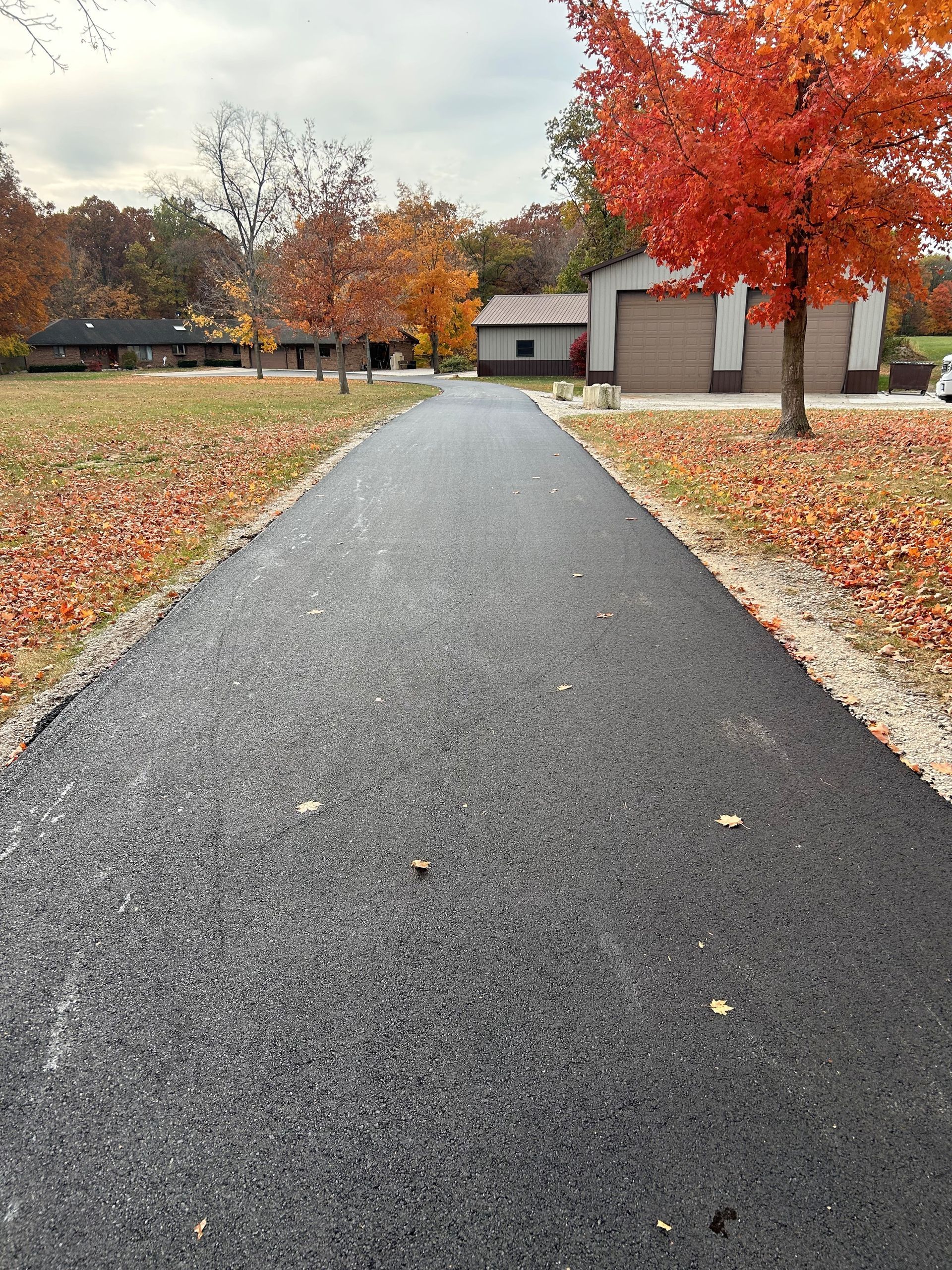 A man is painting a parking lot with a broom.