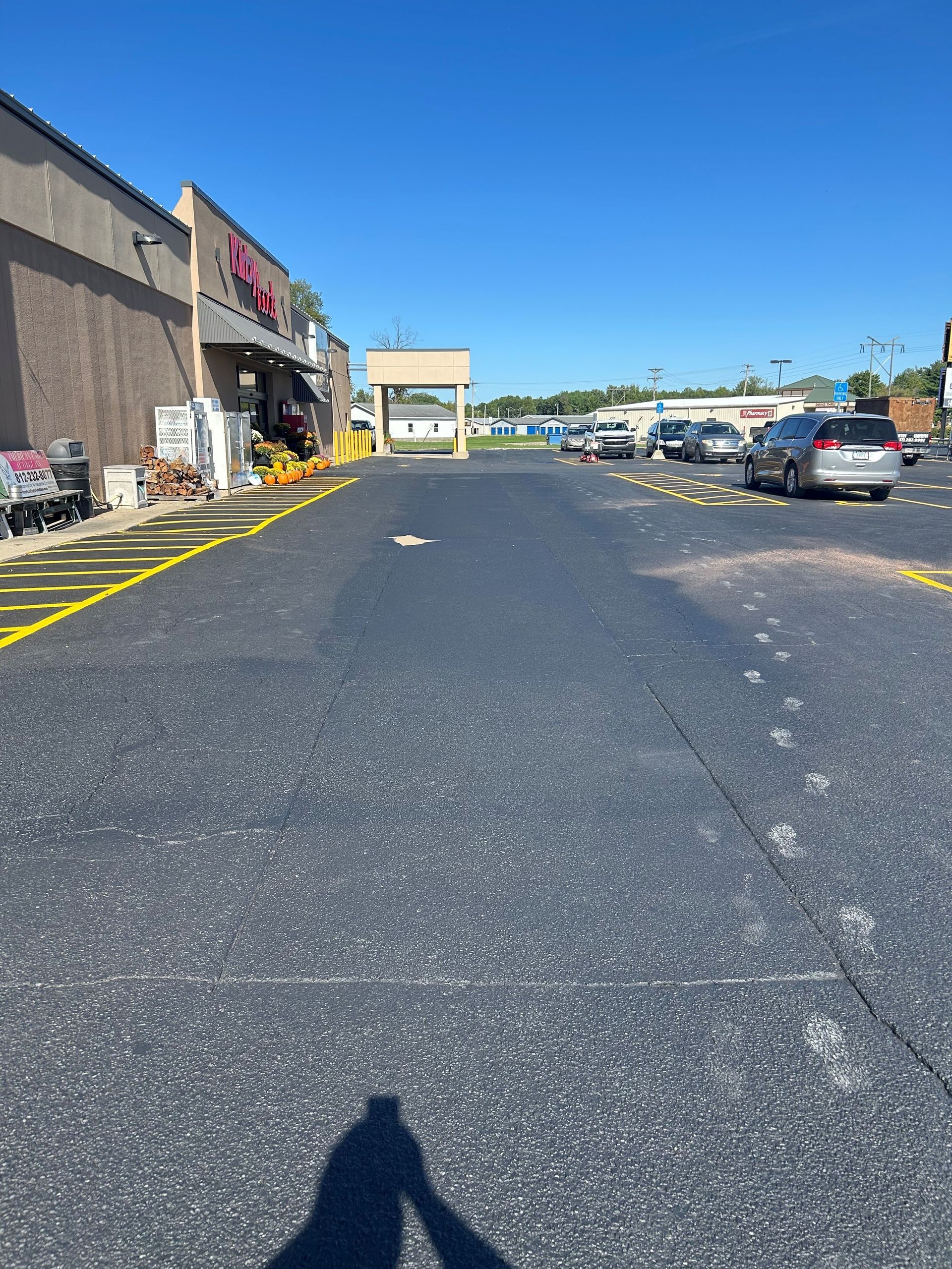 A parking lot with cars parked in front of a store.