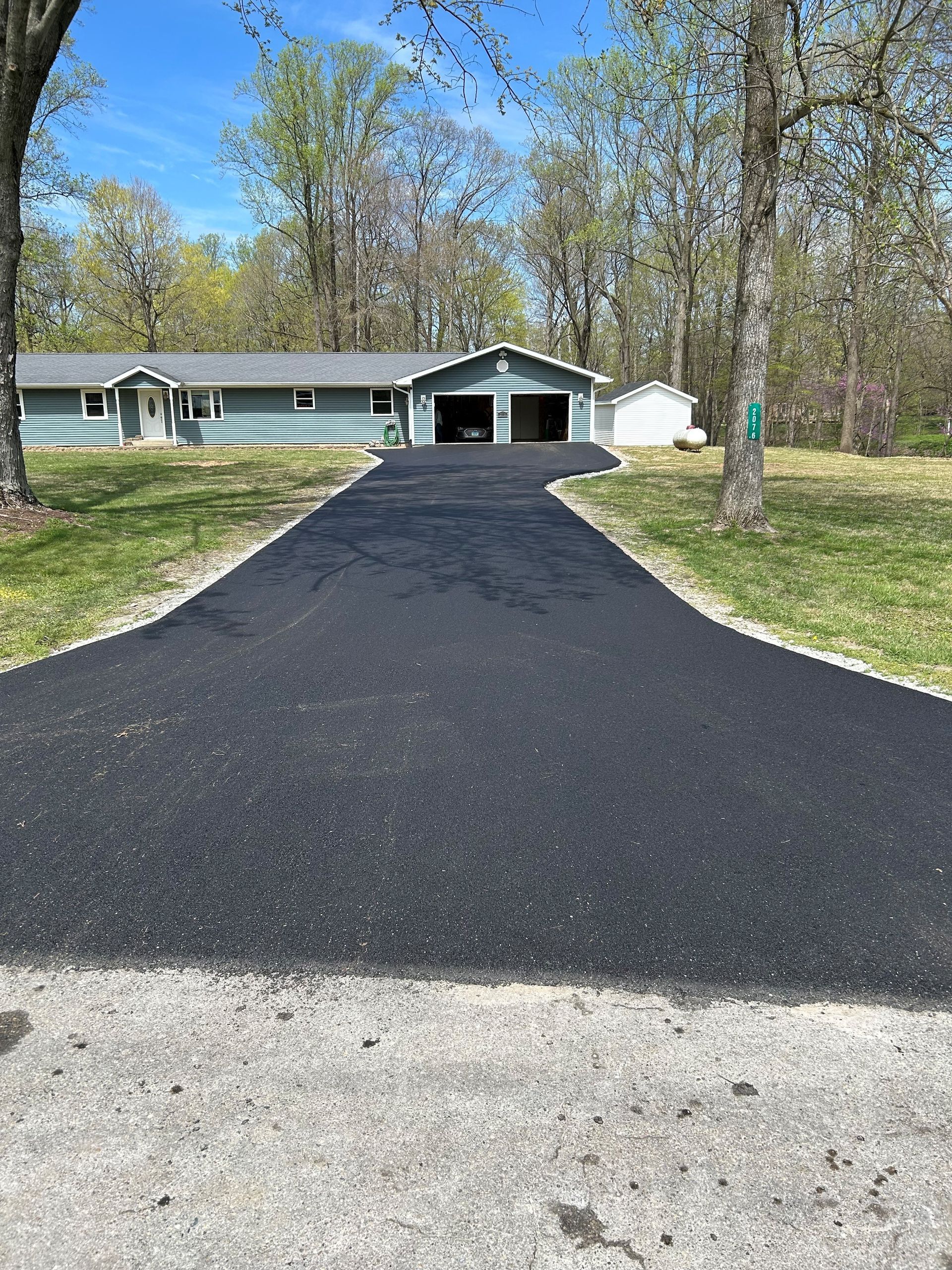 A driveway leading to a house with a garage.