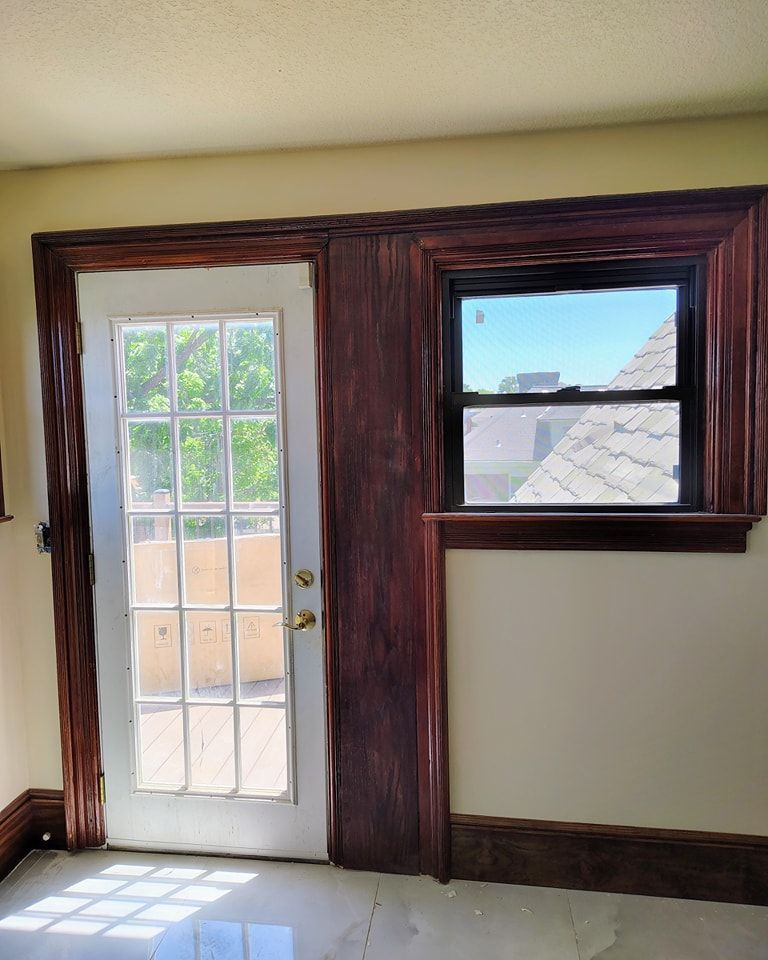 An empty room with a french door and a window.