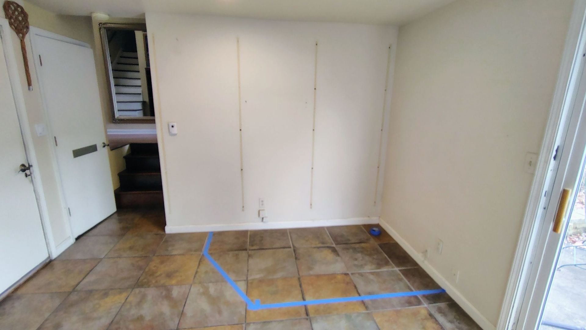 An empty room with a blue line on the floor.