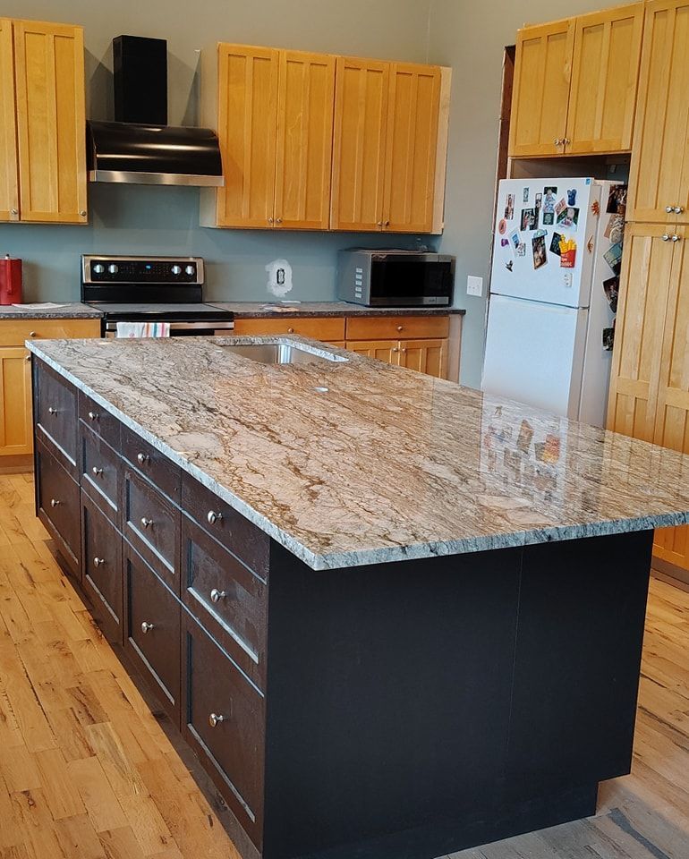 A kitchen with a large island and a refrigerator