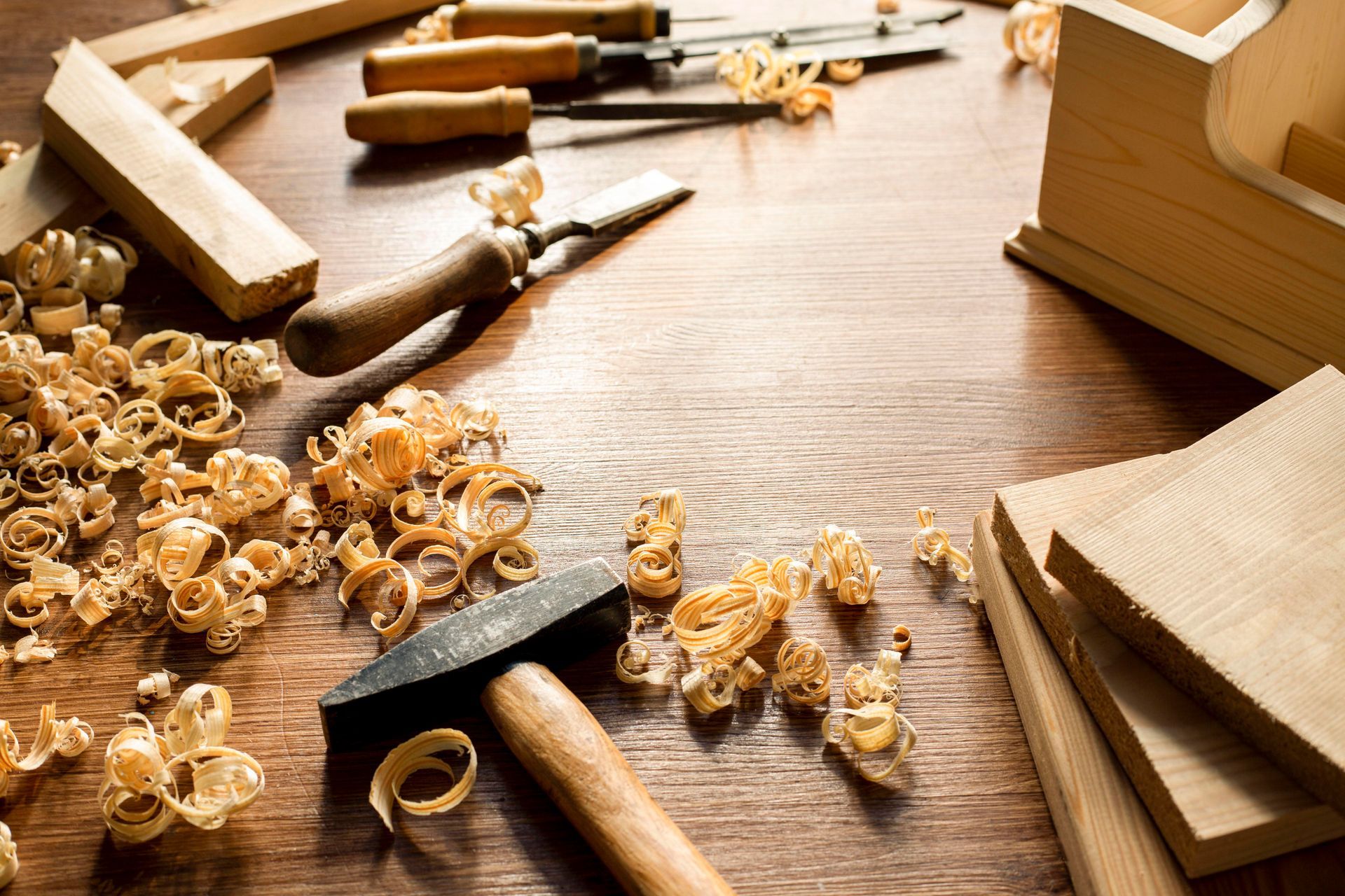 Carpentry tools and wood shavings on a wooden surface, ready for woodworking.