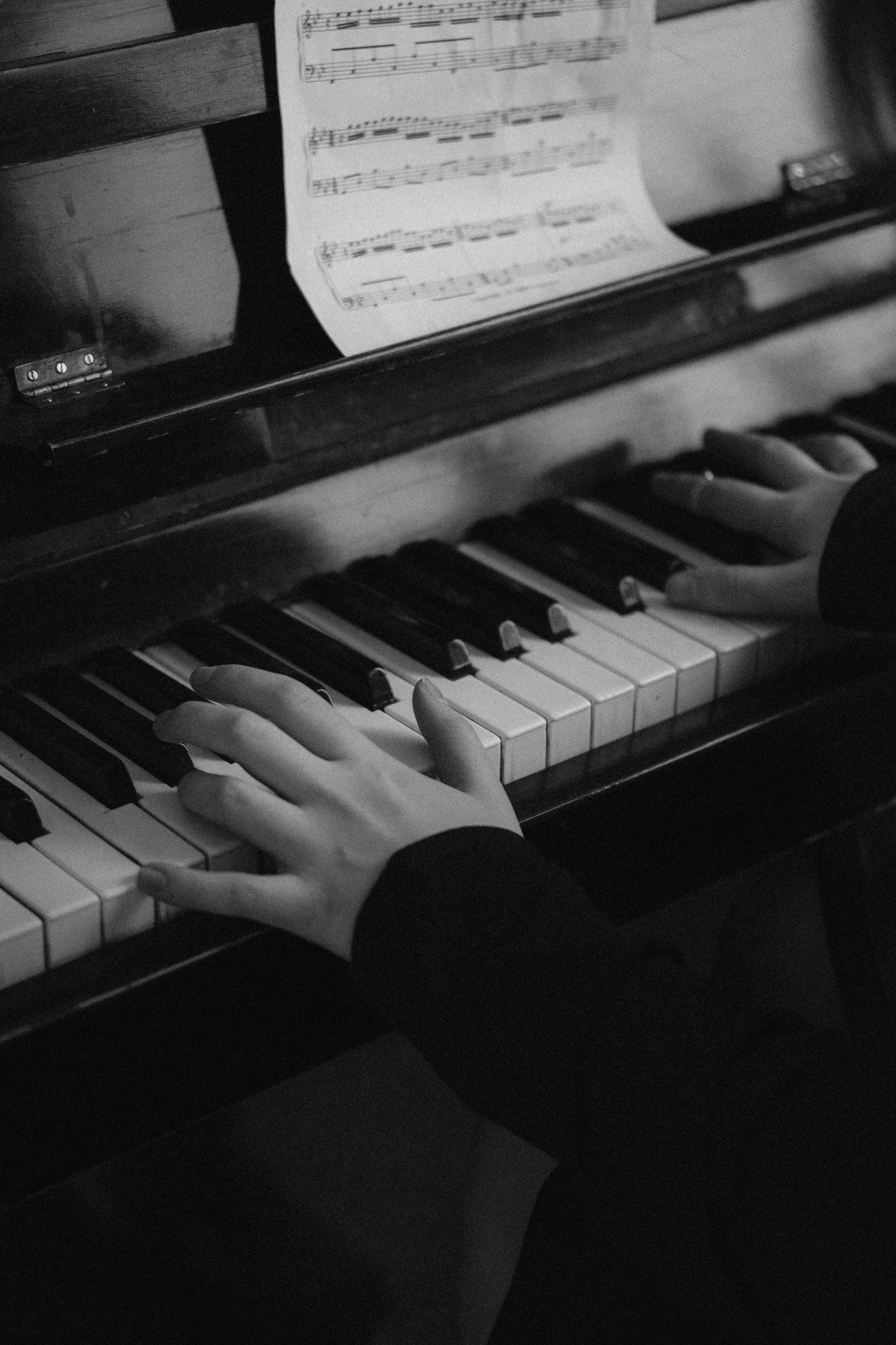 Black and white close-up of piano keys stretching into the distance
