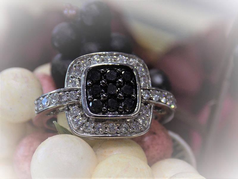Diamond ring with black center stones on a bed of candies