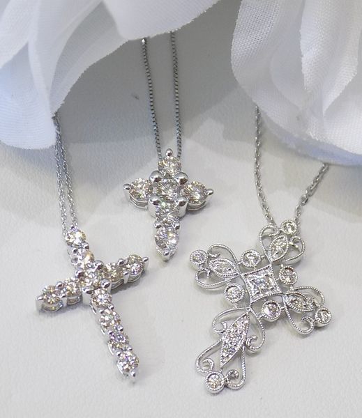 Three diamond-studded cross necklaces on silver chains