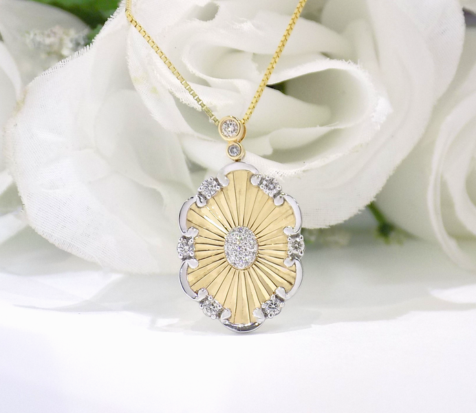 Gold pendant necklace with a sunburst design and diamonds