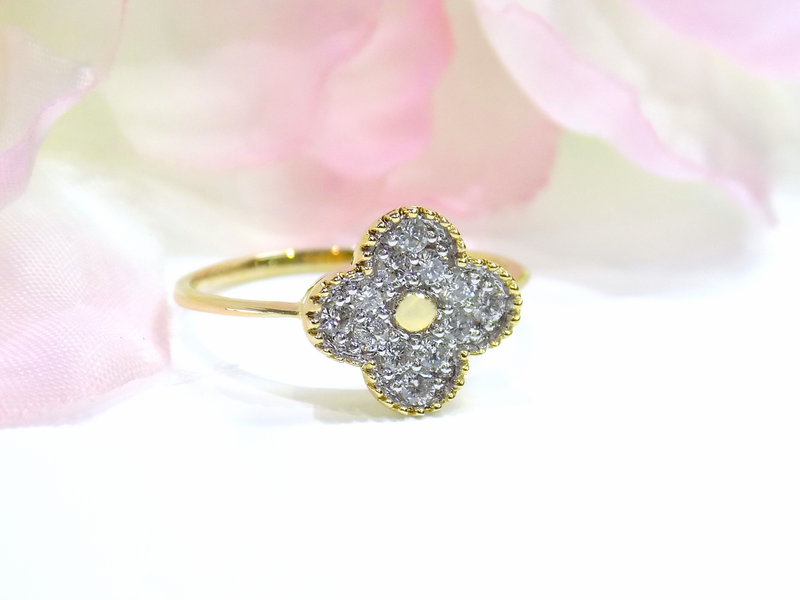 Gold ring with four-leaf clover design encrusted with small, sparkly stones