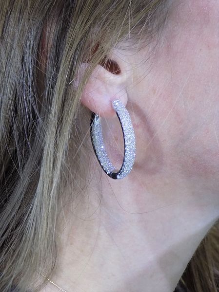 Woman wearing a silver hoop earring covered in small